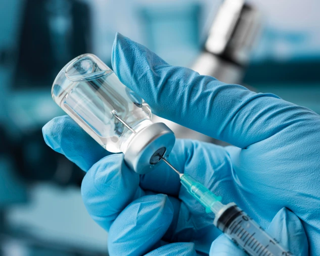 Seringa e frasco de medicamento em ambiente clínico